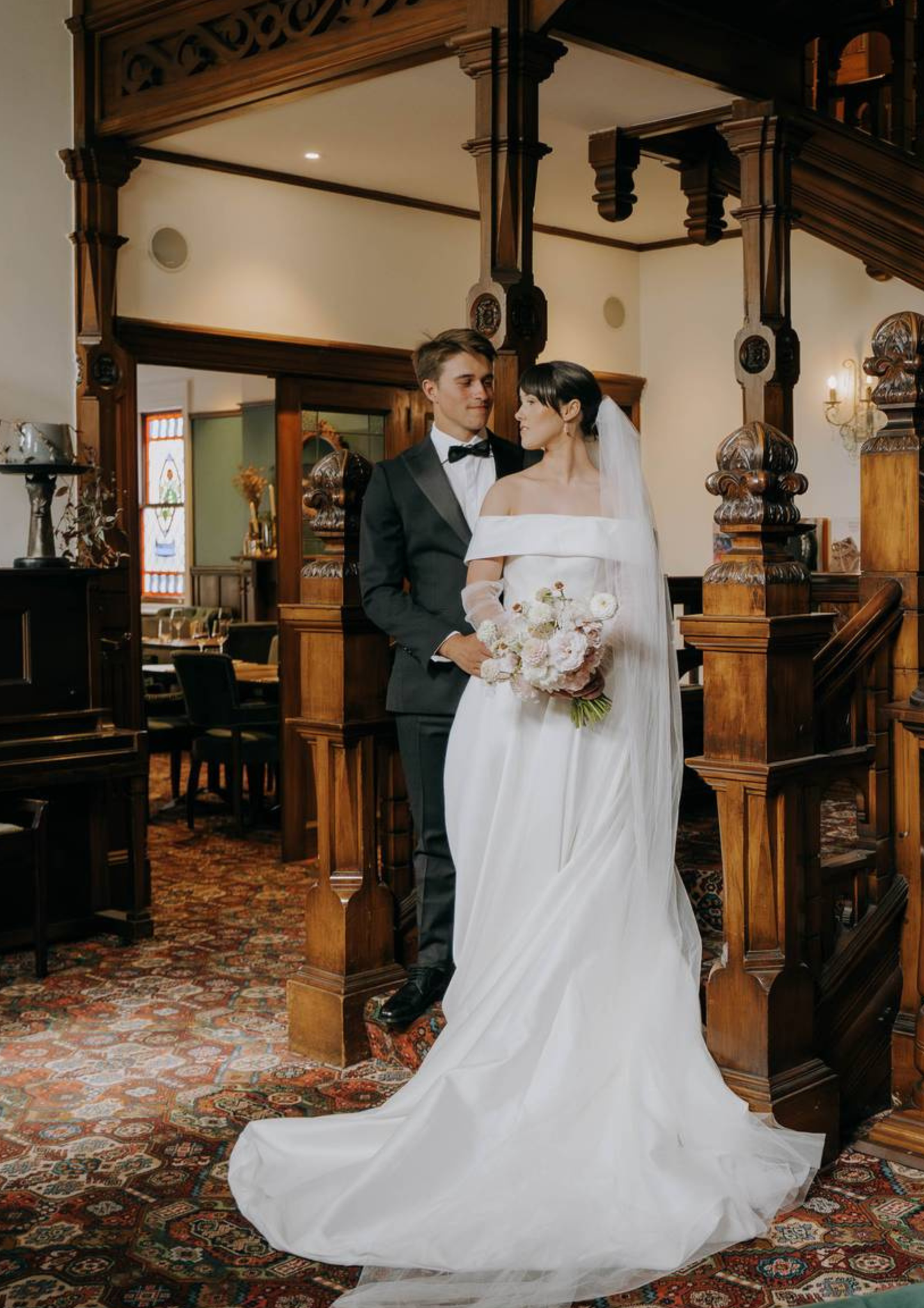 Wedding couple standing in a vintage room with wooden decor.
