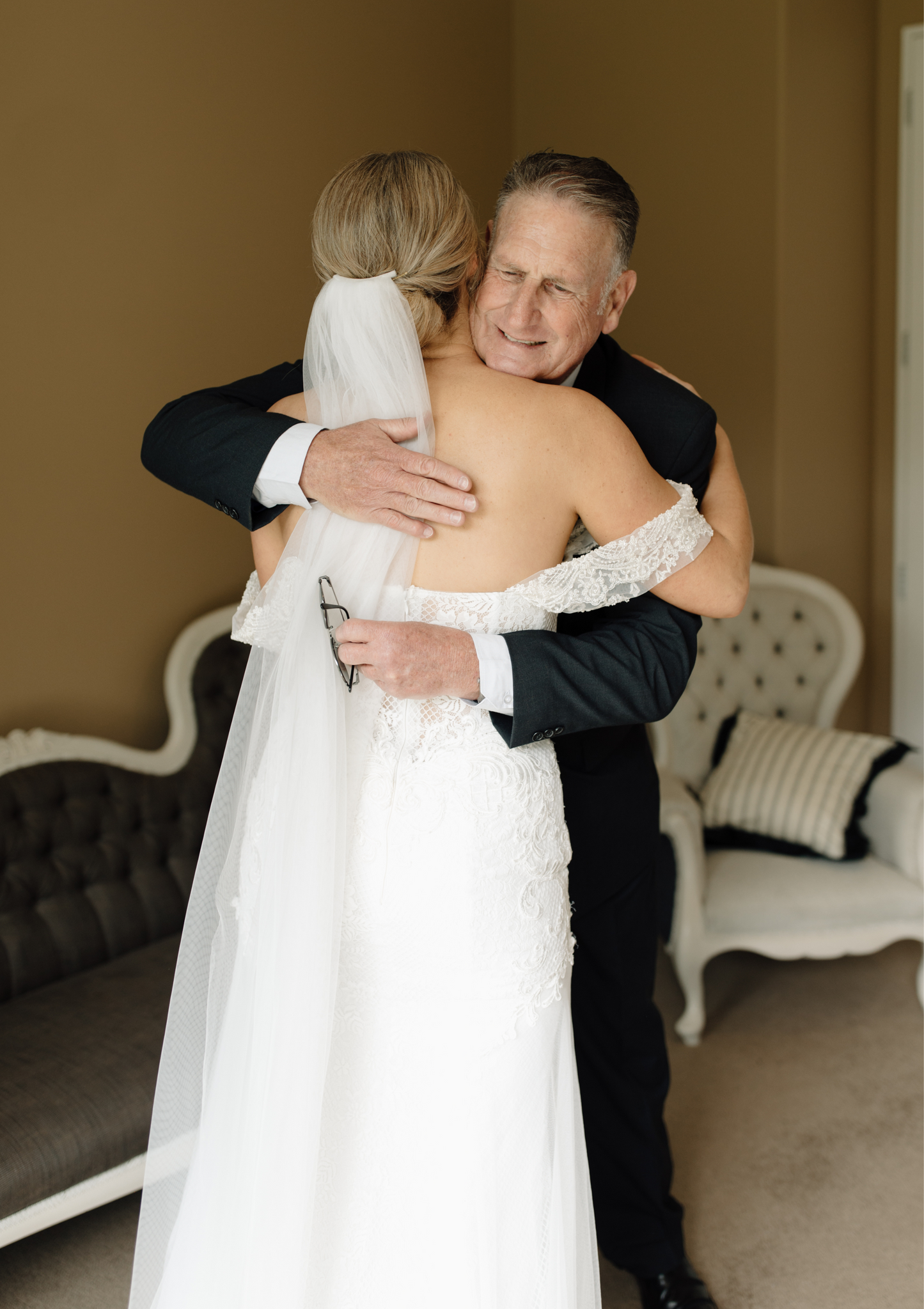 Bride wearing 3m drop veil with updo hairstyle, backless gown
